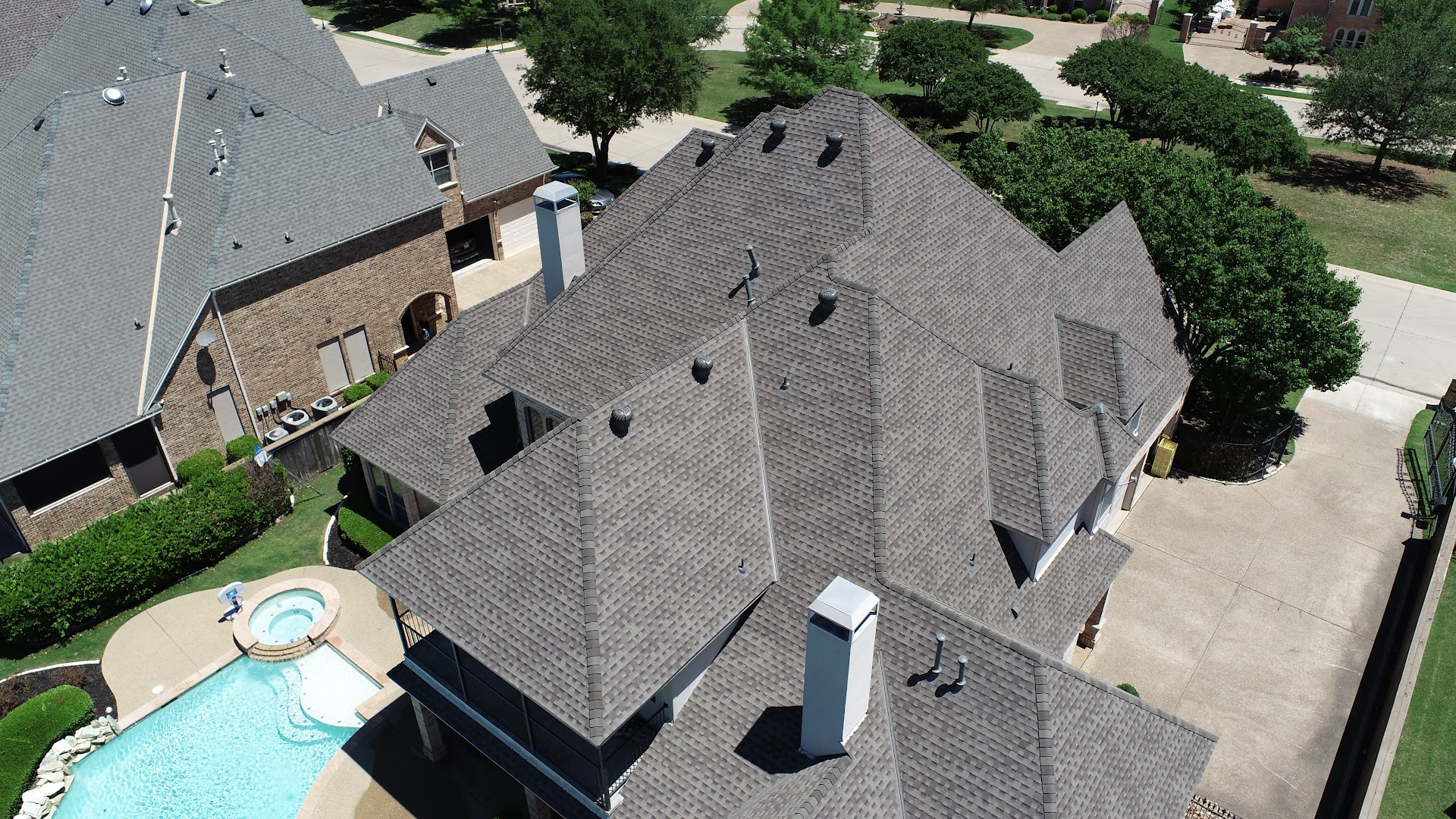 Aerial view of a completed gray shingle roof by RJW Construction